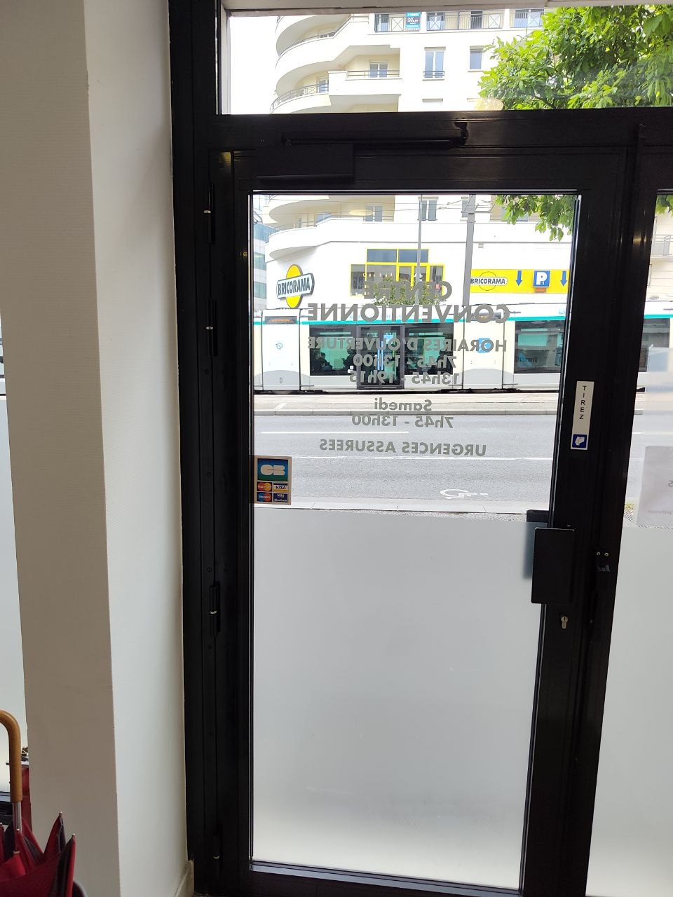 Barre de pivotement installée sur porte d’entrée vitrée de local professionnel